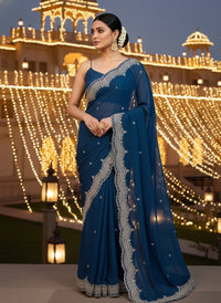 Elegant woman in a vibrant Star Georgette Party Wear Saree featuring heavy golden embroidery and intricate Moti (pearl) work