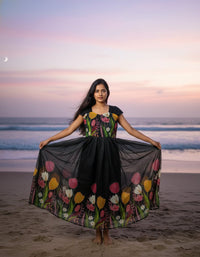 Model in a Midnight Garden purple maxi gown with a vibrant tulip print and delicate ruffle details, perfect for elegant evening events.