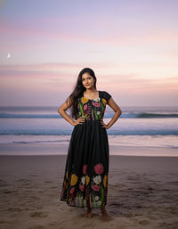 Model in a Midnight Garden purple maxi gown with a vibrant tulip print and delicate ruffle details, perfect for elegant evening events.