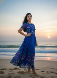 Model in a Midnight Garden purple maxi gown with a vibrant tulip print and delicate ruffle details, perfect for elegant evening events.