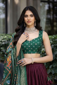 Traditional Patola Paithani Dola Silk Lehenga featuring a vibrant print, intricate foil work, and a delicate Gotta Patti lace border with decorative tassels.