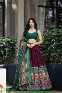 Traditional Patola Paithani Dola Silk Lehenga featuring a vibrant print, intricate foil work, and a delicate Gotta Patti lace border with decorative tassels.