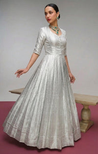 Model showcasing a Kanjivaram Zari Weaving Gown Set with a Koti jacket, highlighting intricate gold zari patterns and luxurious fabric, ideal for festive Indian events.